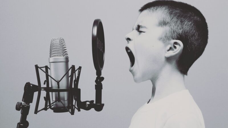 boy singing on microphone with pop filter
