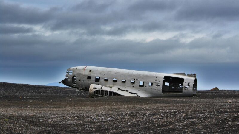 crushed plane on soil under gray sky during daytime