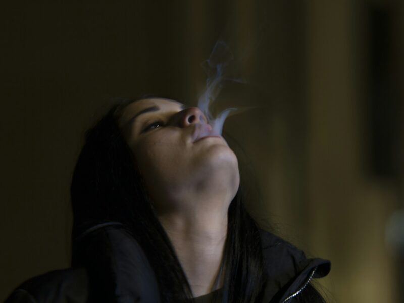 woman standing while blowing smoke