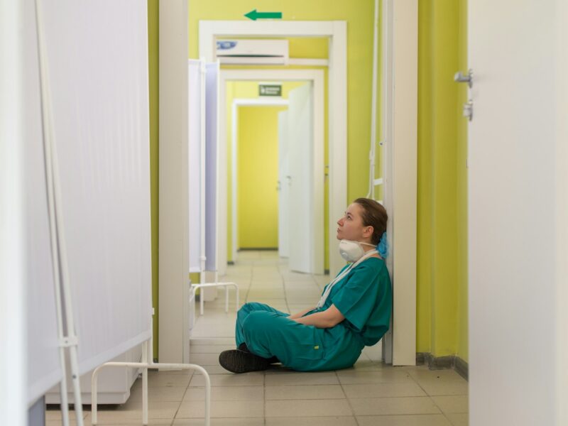 child in blue hoodie sitting on floor
